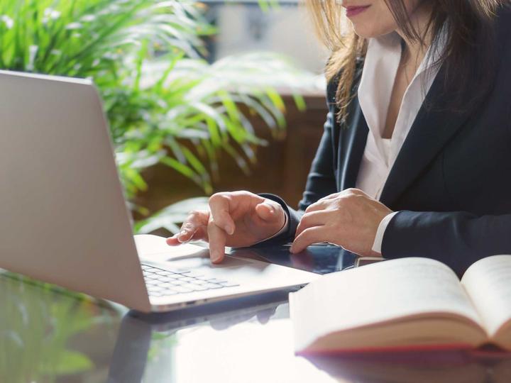 Woman in a suit at a laptop